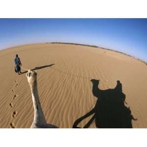  A Tuareg Tribesman Leads His Camel Through the Dunes of 