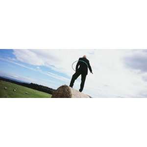  Man Standing on a Hay Bale and Playing with a Plastic Hoop 