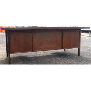 Mid Century wood desk with laminate top. Features 5 drawers and a 