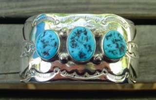 etched southwestern designs and has 3 bezel set pieces of turquoise 