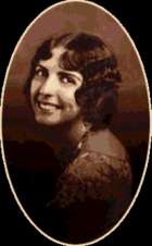 studio photograph of a young woman looking over her shoulder.