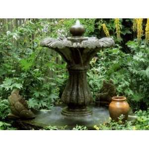 Stone Fountain in Garden with Small Sculptures and Ligularia 